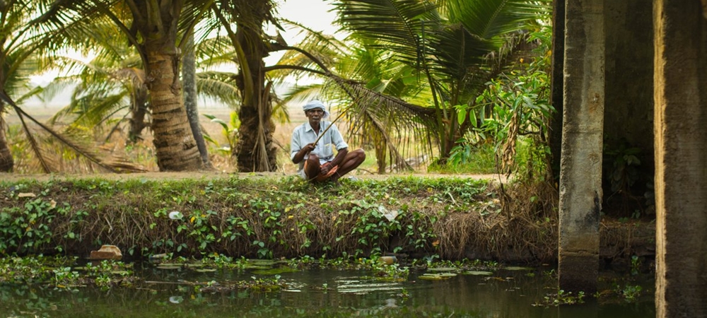 An elderly villager fishing in a lake