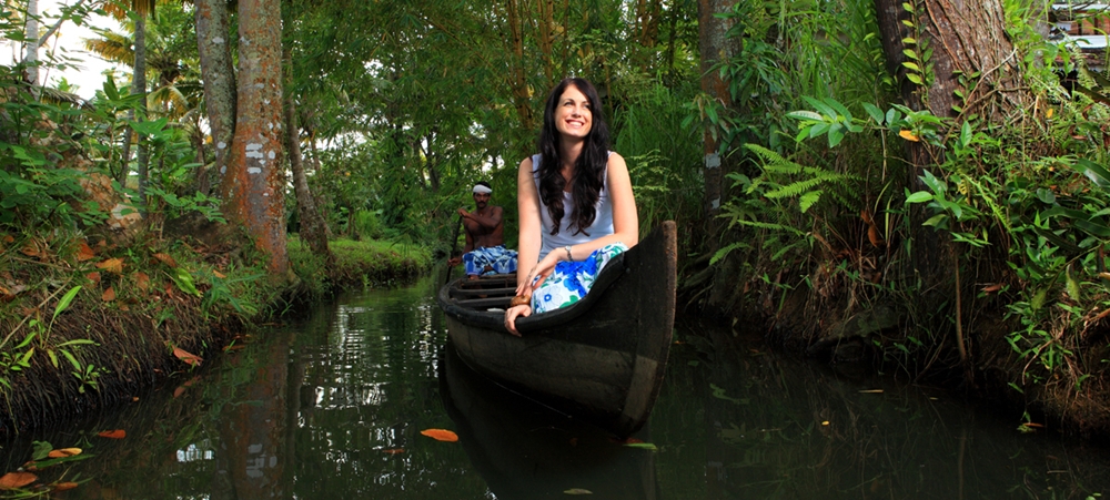 Tourist girl enjoying the backwaters on a canoe ride