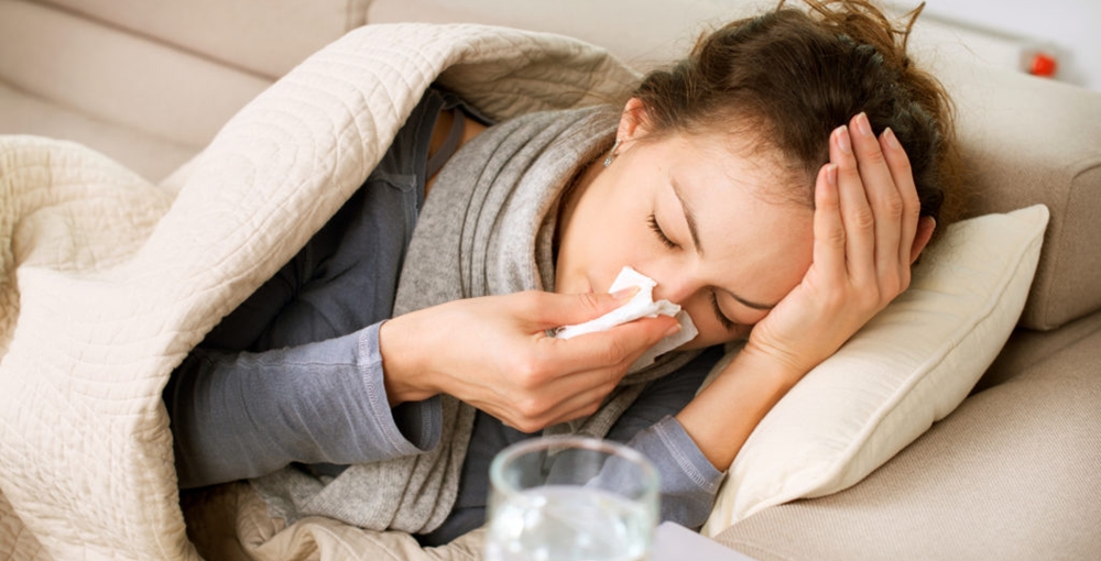 A woman down with flu and headache
