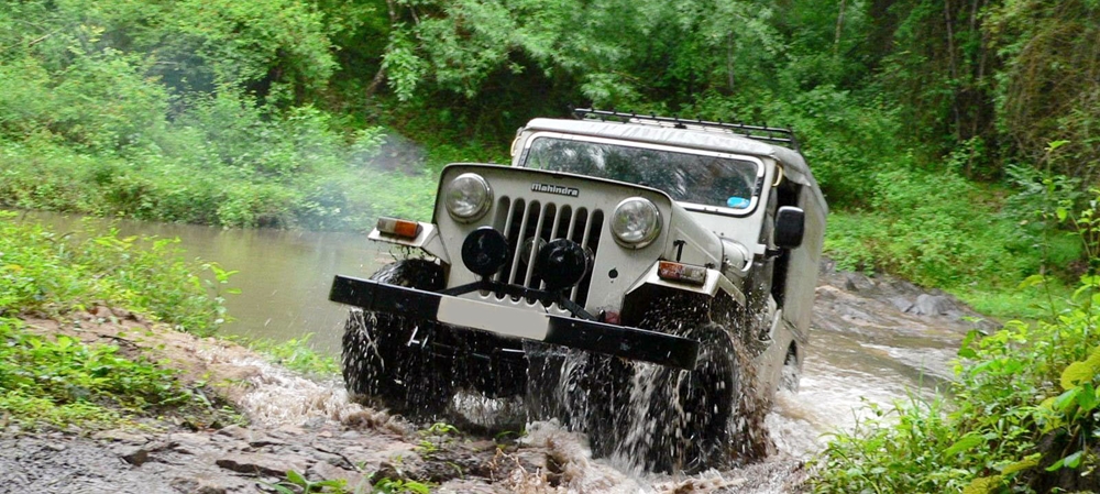 Jeep going across a river in Thekkady