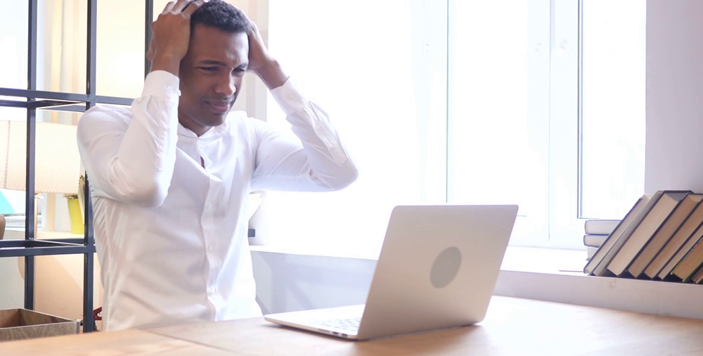 A confused man looking at his laptop