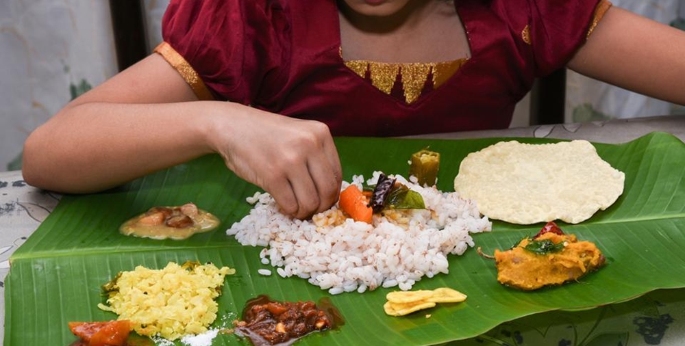 A girl eating Sadhya with her hand