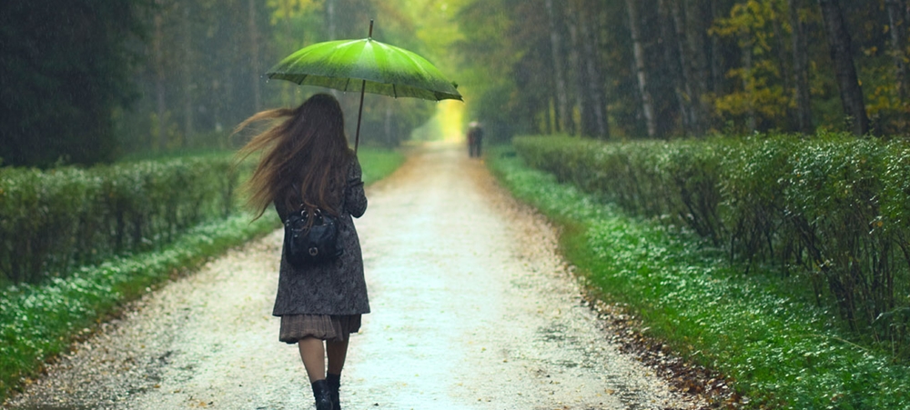 Girl in raincoat walking in the rain