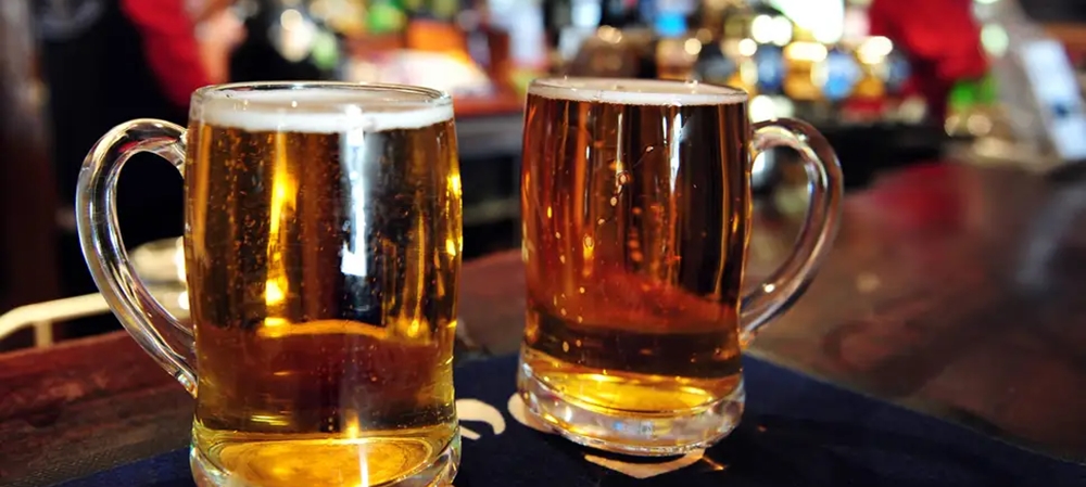 Two full glasses of beer on the bar table