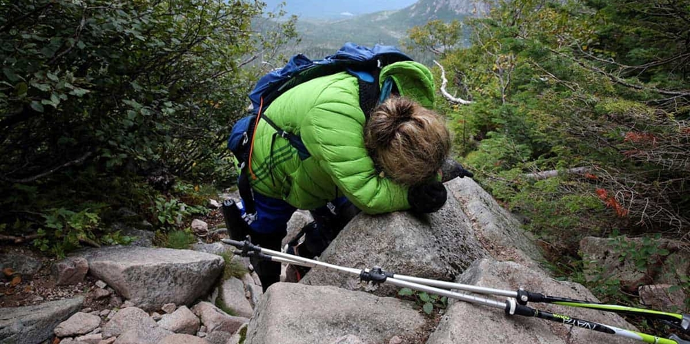 Woman completely tired trying to climb a mountain