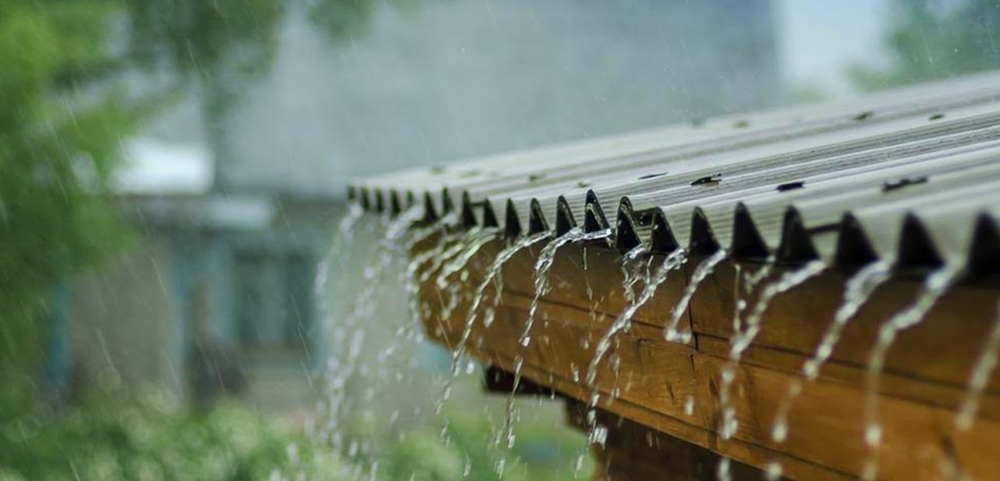 Rain water falling from the roof of a house