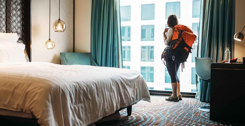 Traveler looking out from her hotel room