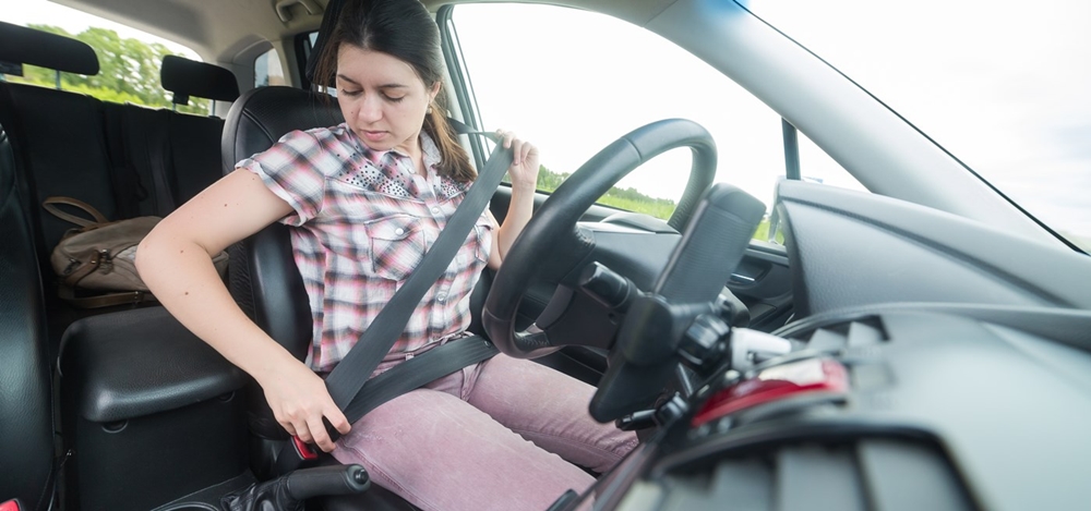 Woman wearing seat belt before starting the car