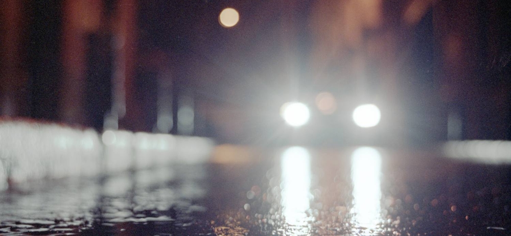 Car with high beam in the rain